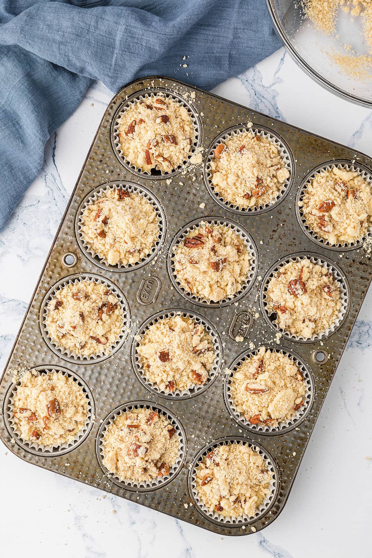 muffin pan filled with batter for orange muffins