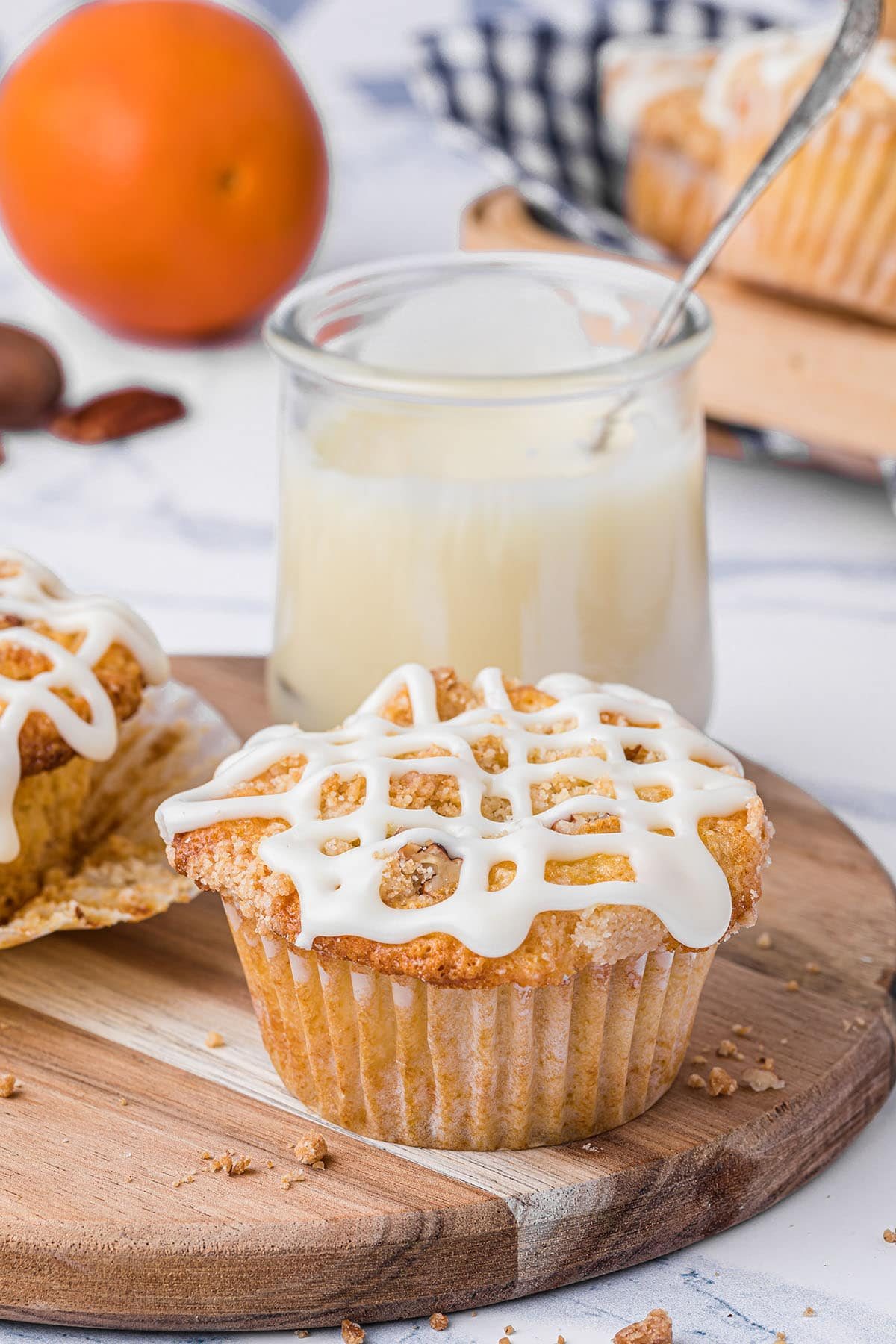 muffin with icing on a table with a jar of icing in the background