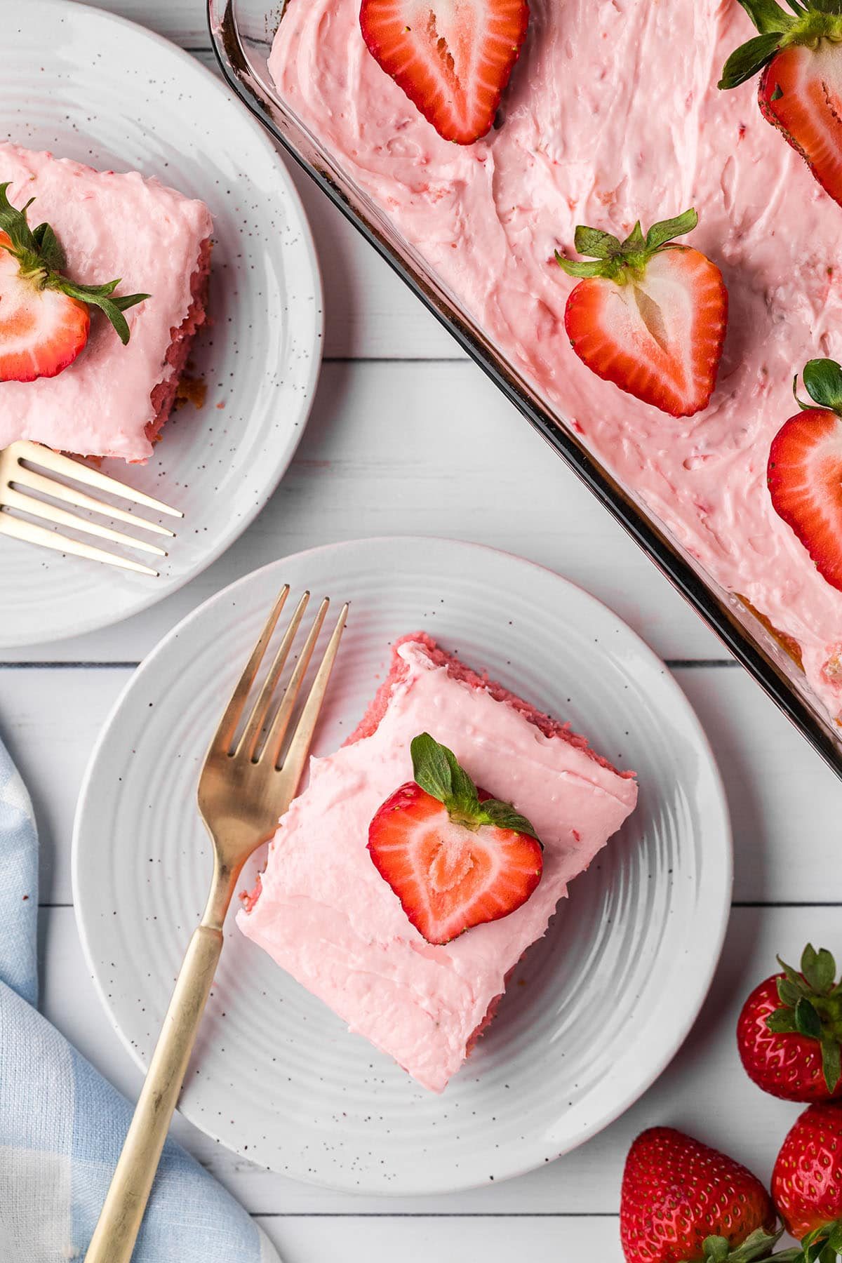 2 servings of strawberry cake topped with fresh strawberries.