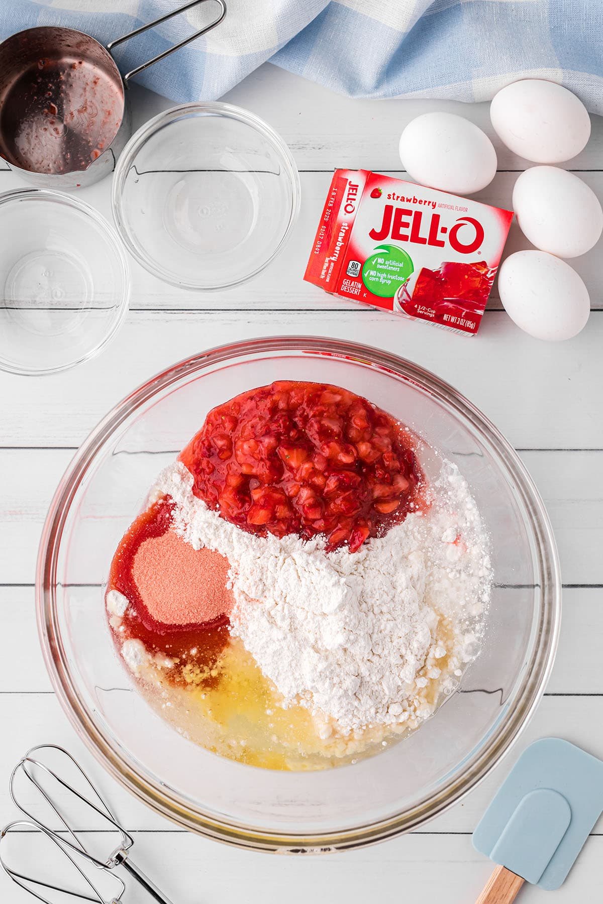 fresh strawberry cake batter with Jello mix in a glass mixing bowl.