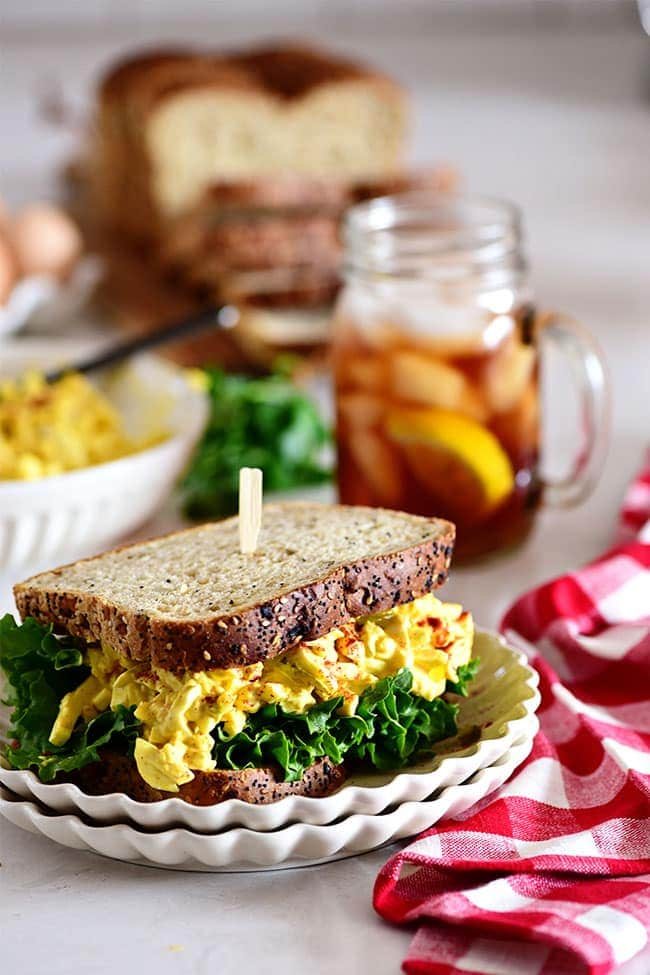 classic egg salad sandwich with a glass of iced tea and red checked napkin