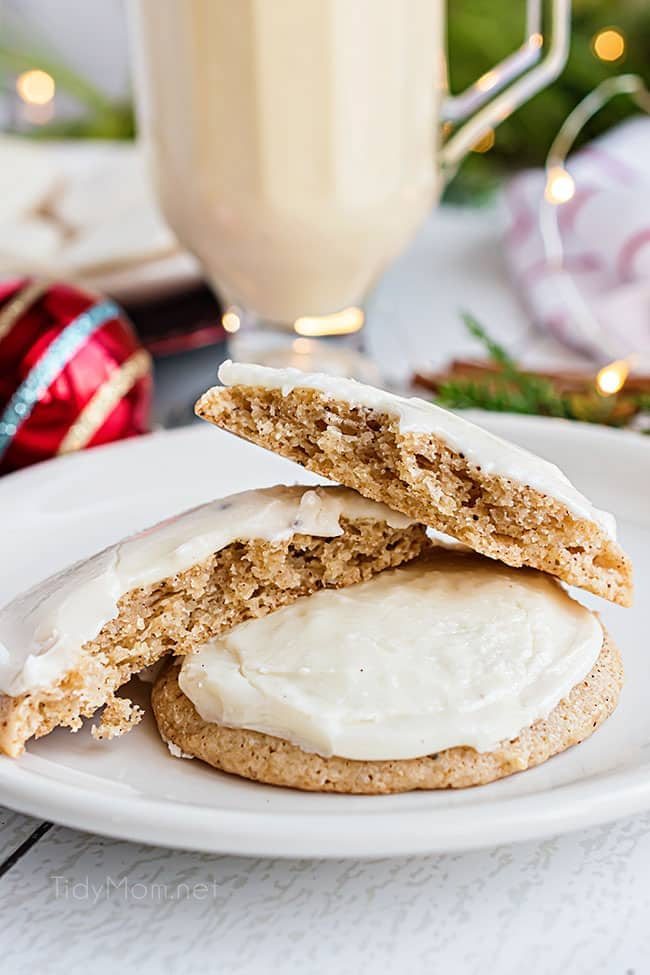 two frosted cookies on a plate with one broke open