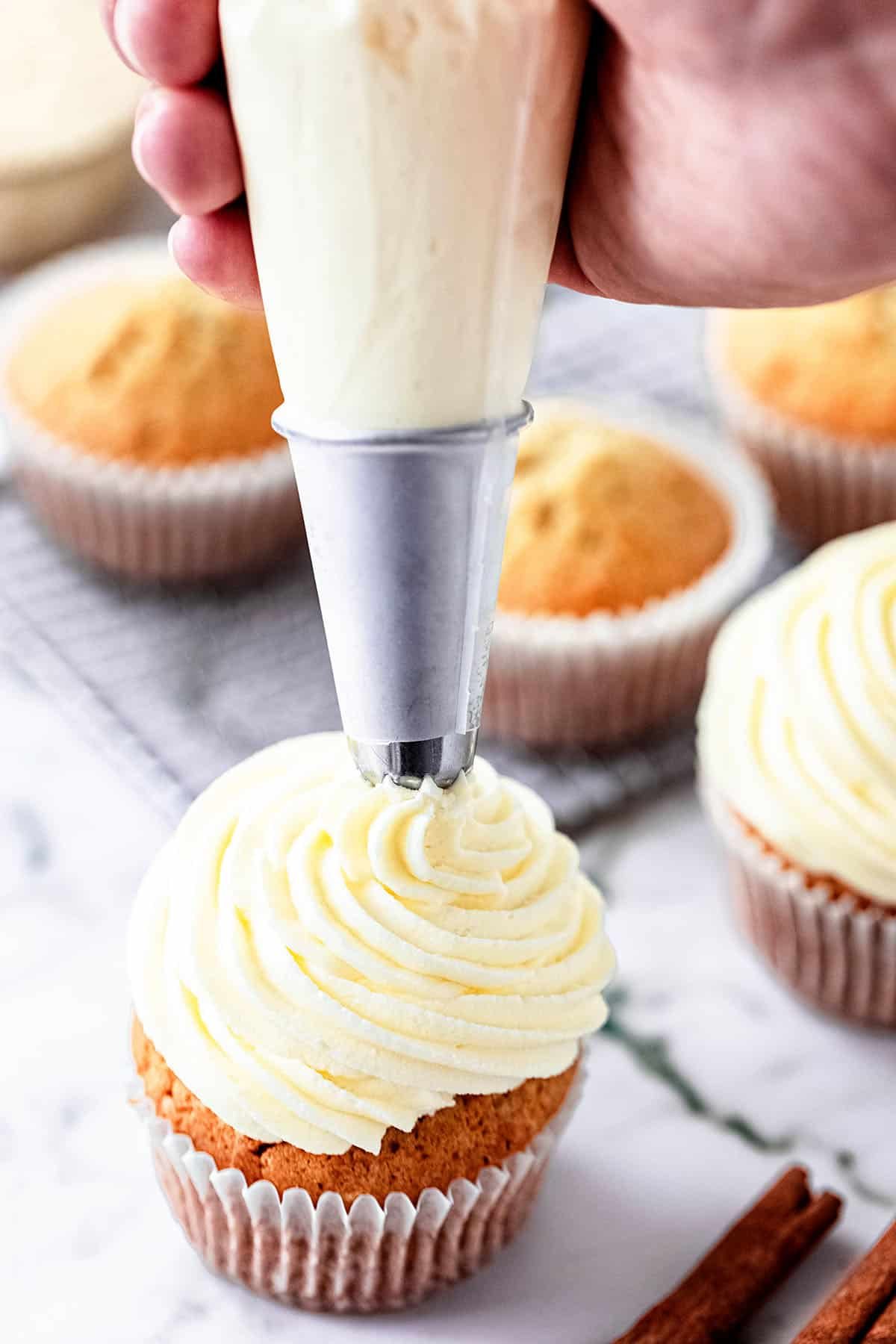 piping buttercream on a cupcake