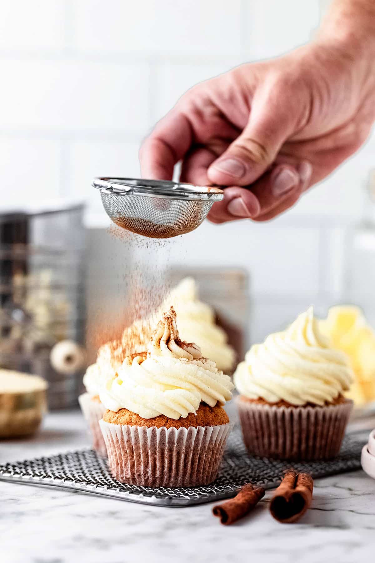 dusting cupcakes with cinnamon