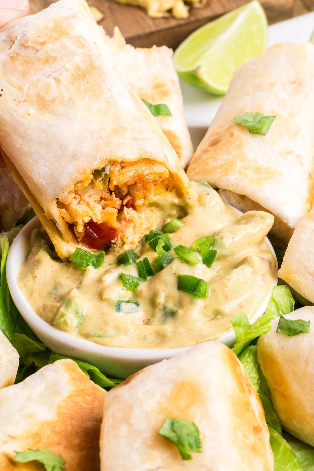dipping a firecracker chicken wrap in avocado sauce