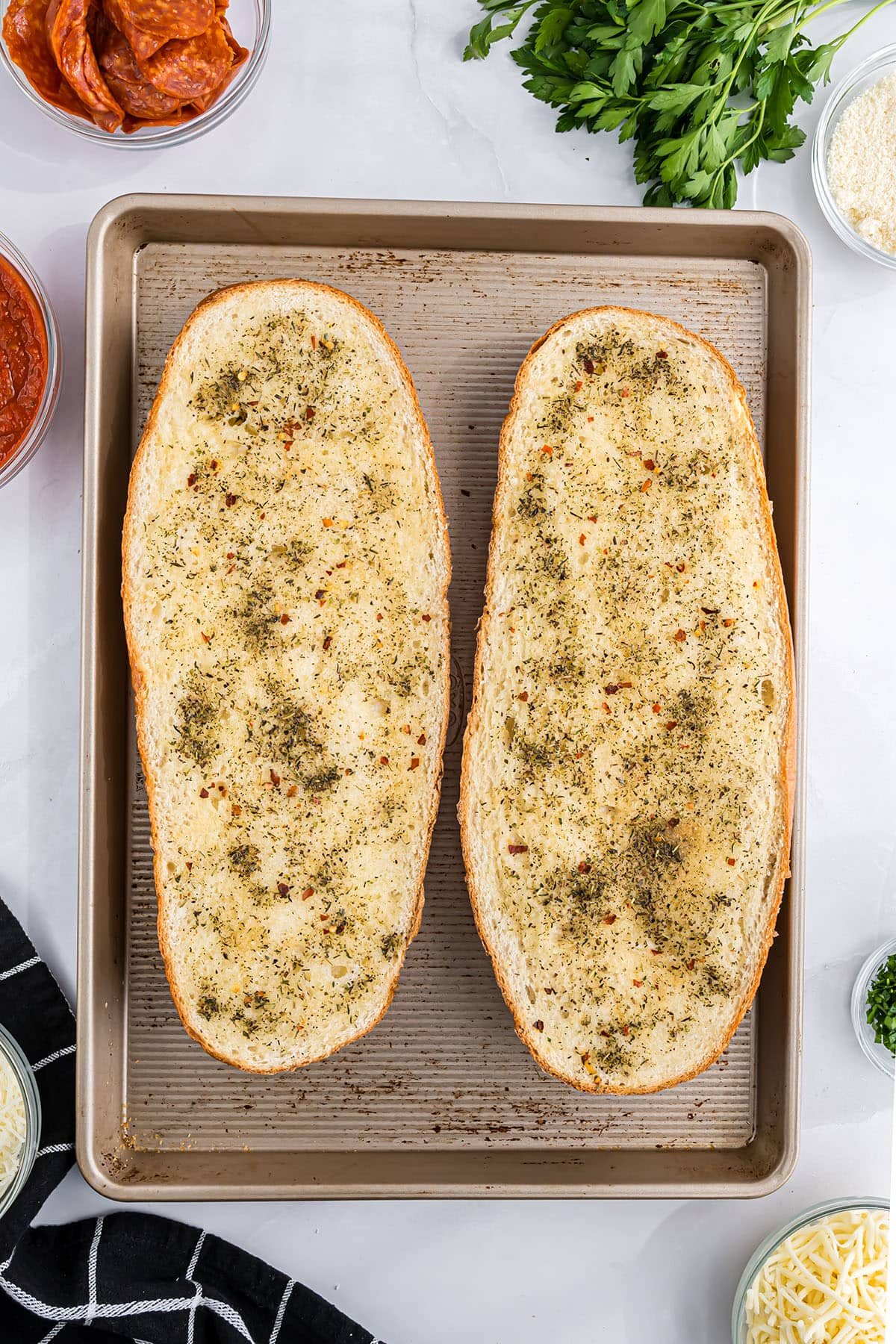 loaf of bread sliced open and toasted with butter and seasonings