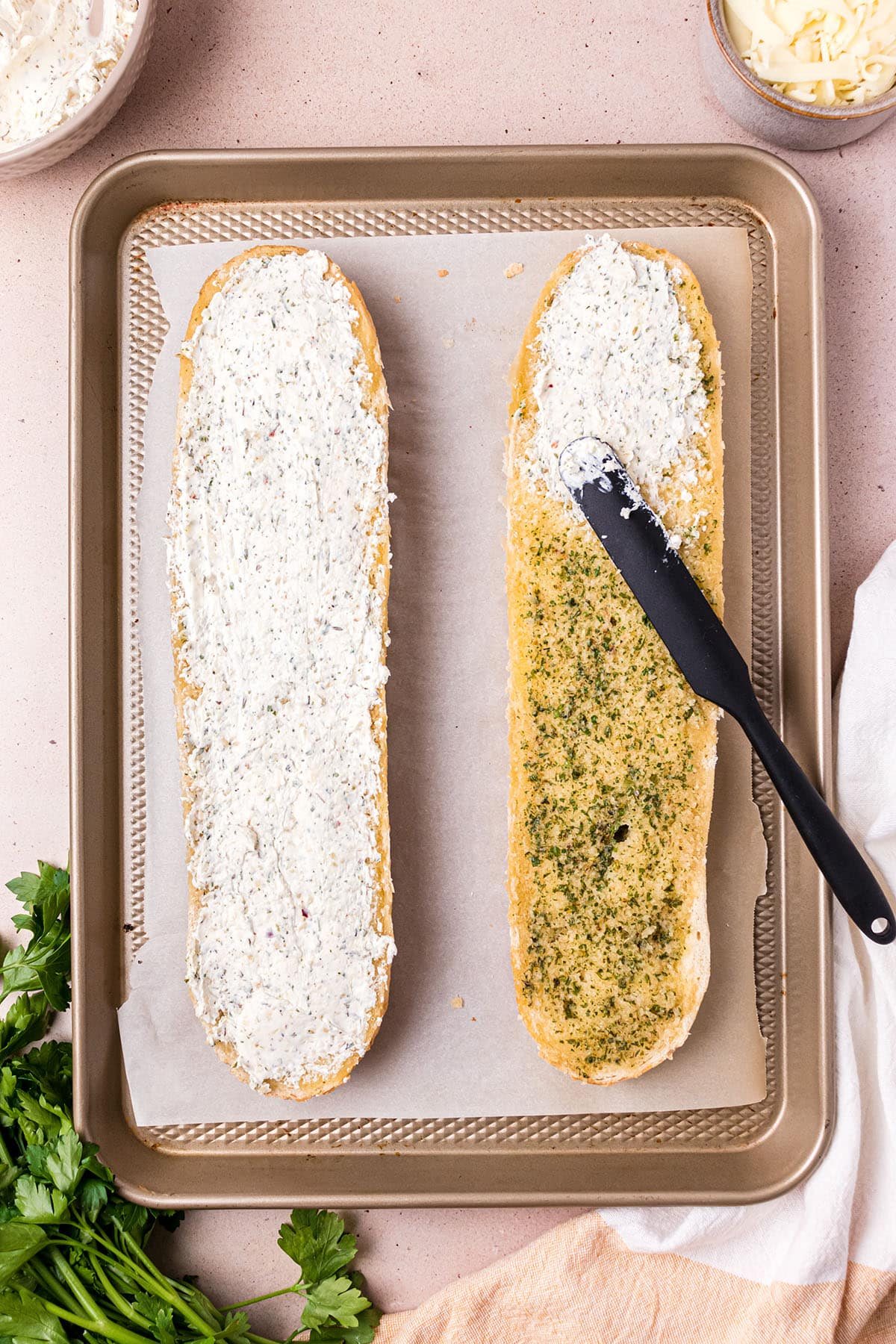 spreading seasoned cheese on warm garlic buttered loaf