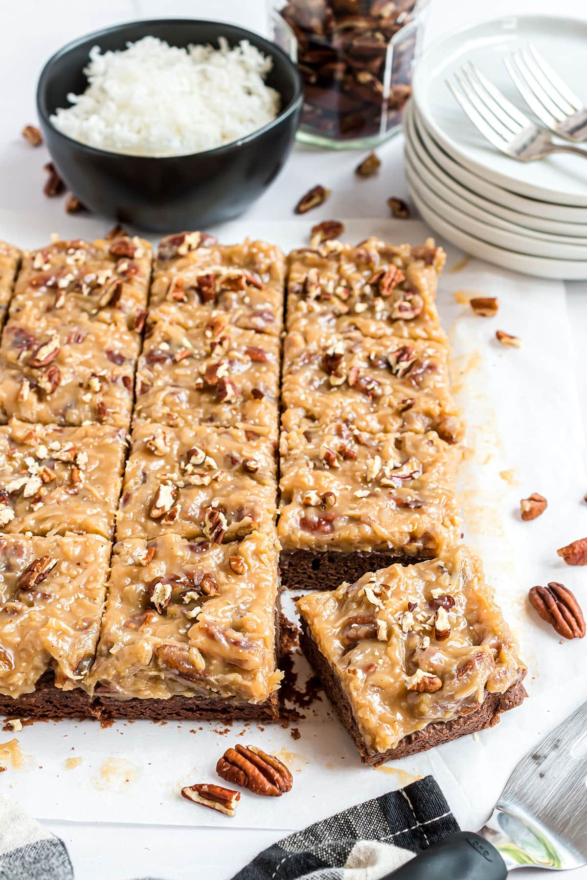 A cut batch of brownies with pecan topping
