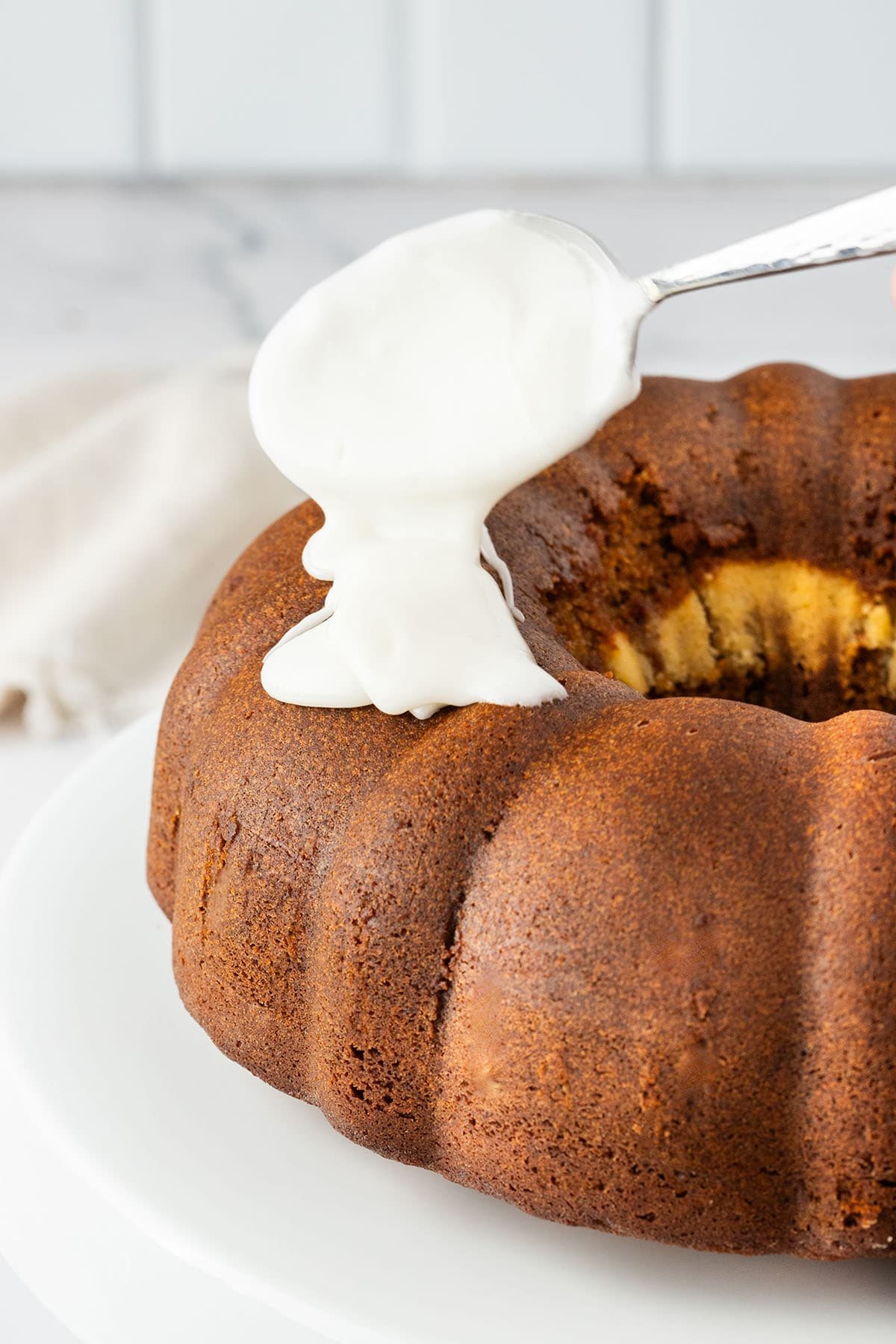 drizzling glaze on a gingerbread bundt cake