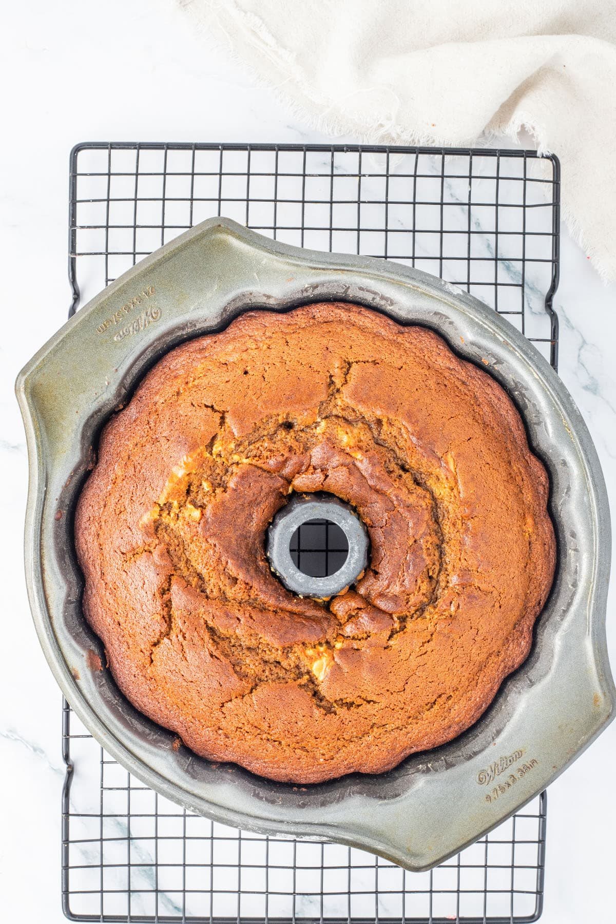 baked cake in bundt pan on a cooling rack