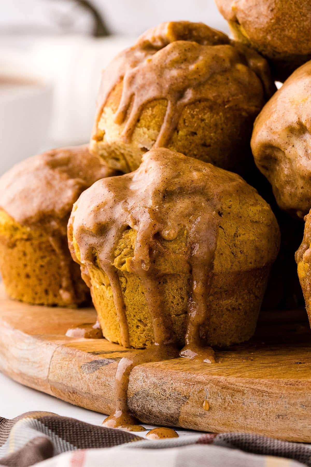 Pumpkin Doughnut Muffins dripping in pumpkin glaze