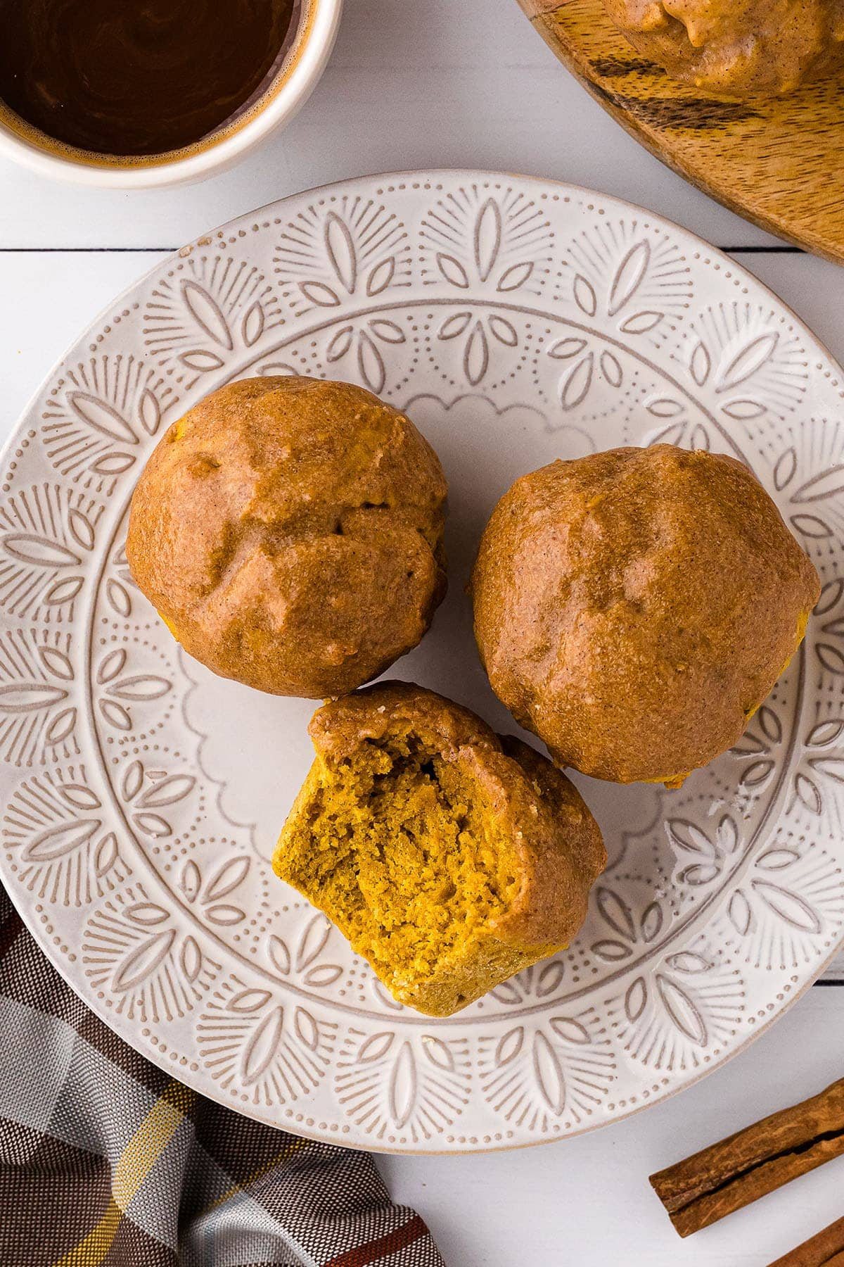 Three doughnut pumpkin muffins on a plate
