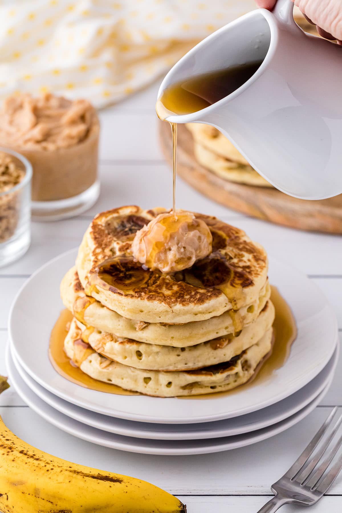 syrup pouring over a stack of pancakes