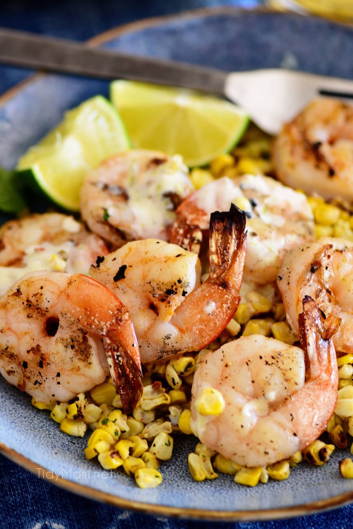 Zesty Shrimp Bowl with Roasted Corn and a creamy lime vinaigrette on a blue plate