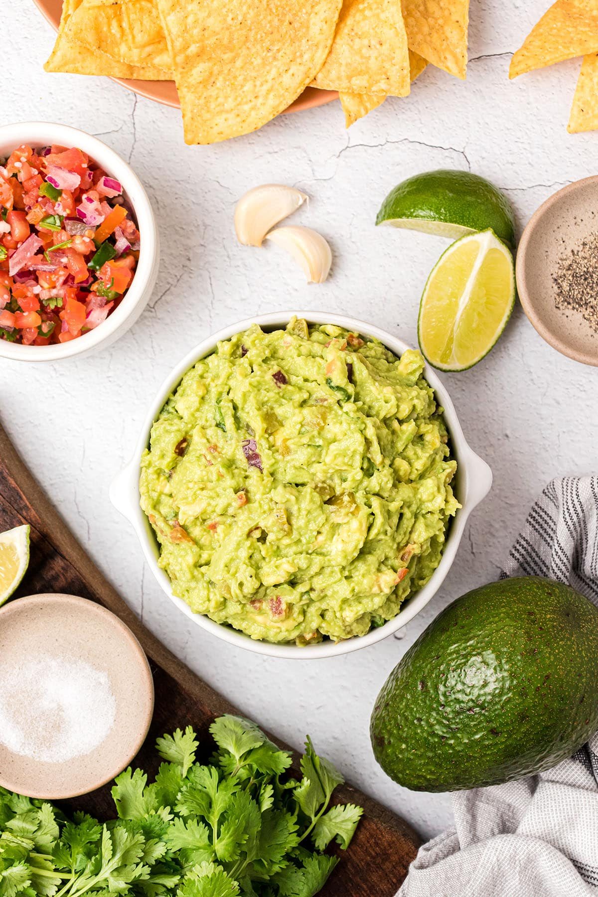 bowl of guac and ingredients around it