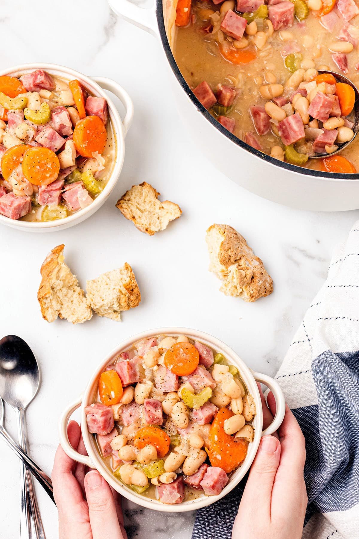 Hands warming on a bowl of ham and beans