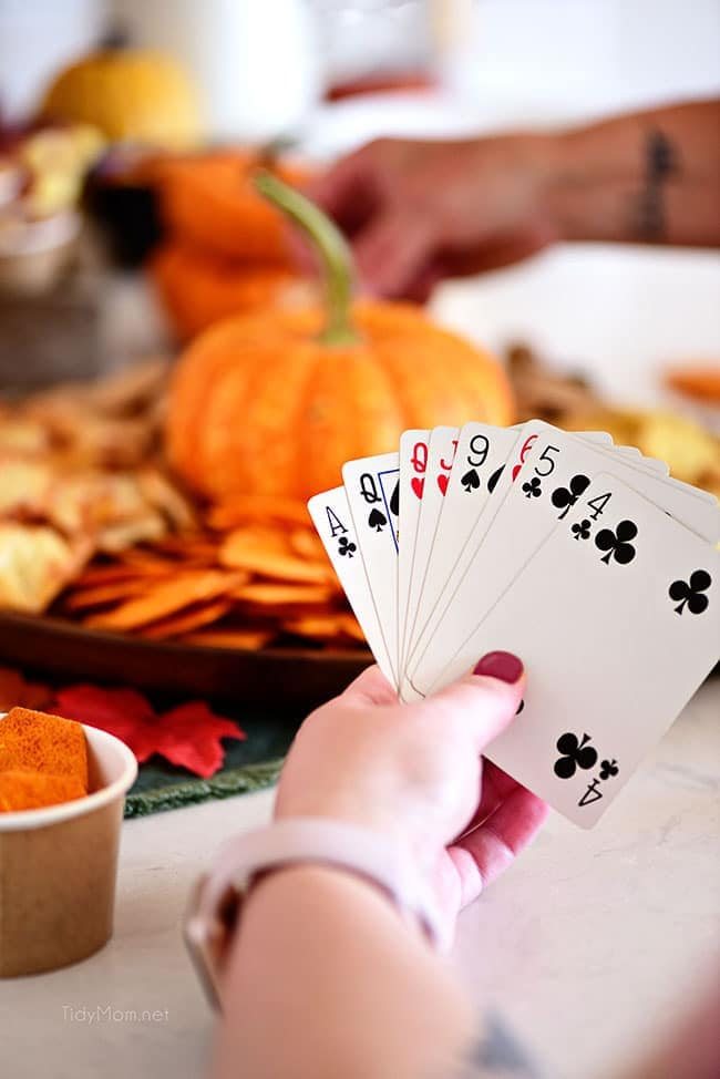 girl holding cards with snack tray in background