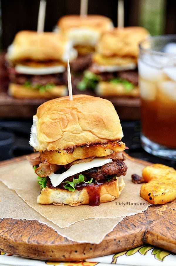 Fire up the grill for this Hawaiian burger recipe. Aloha BBQ Sliders are flavored with BBQ sauce, served on sweet rolls with cheese, pineapple and bacon. Print recipe at cetcu.com