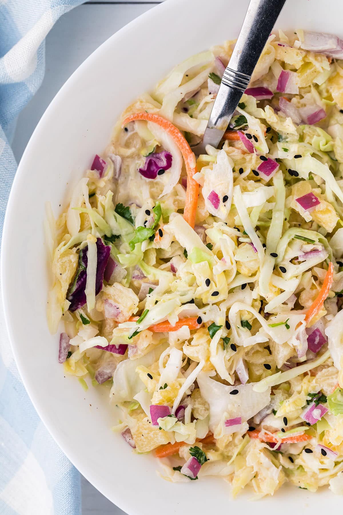 pineapple coleslaw in a serving bowl with a spoon