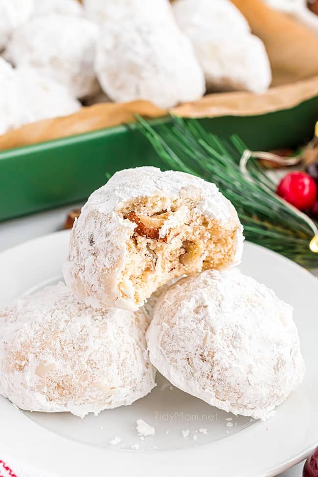 close up of snowball cookies in a green dish