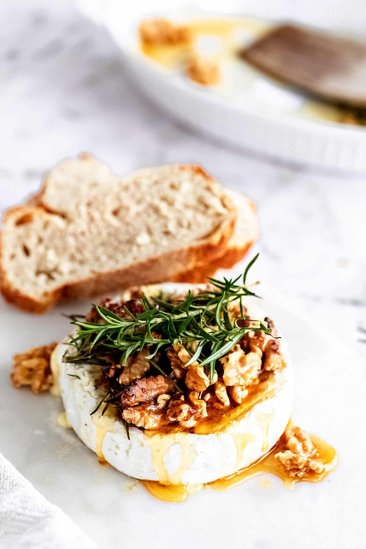 baked brie wheel with honey drizzle, fresh rosemary and bread
