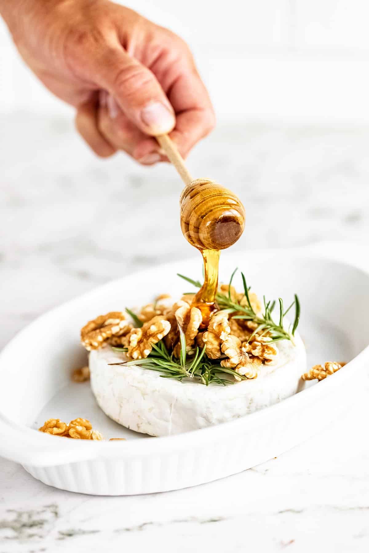 drizzling hone over a brie wheel
