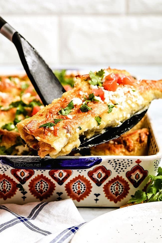 serving enchiladas from a baking dish