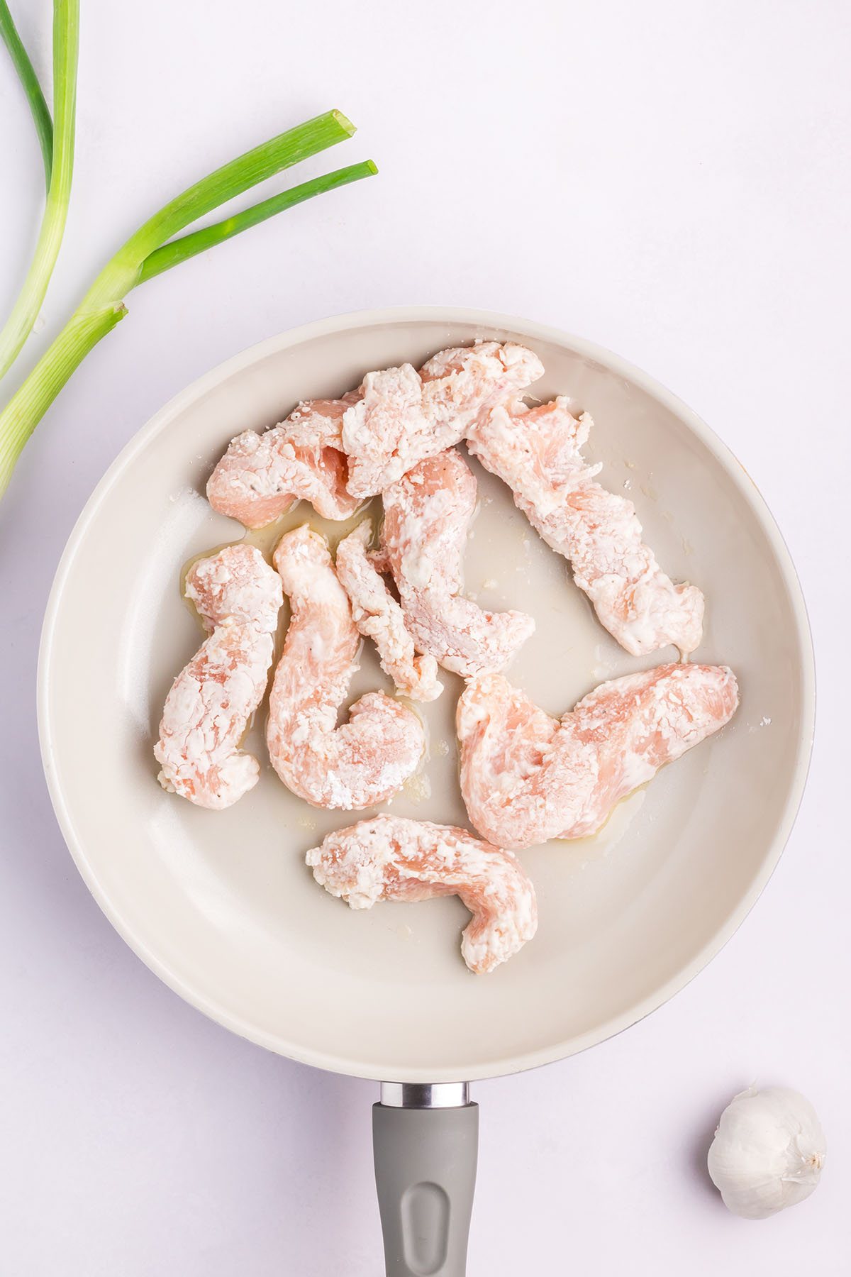 floured chicken in a skillet