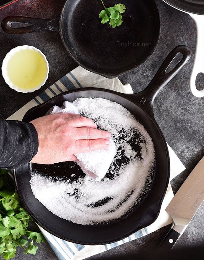 cast iron skillet being cleaned with salt and oil