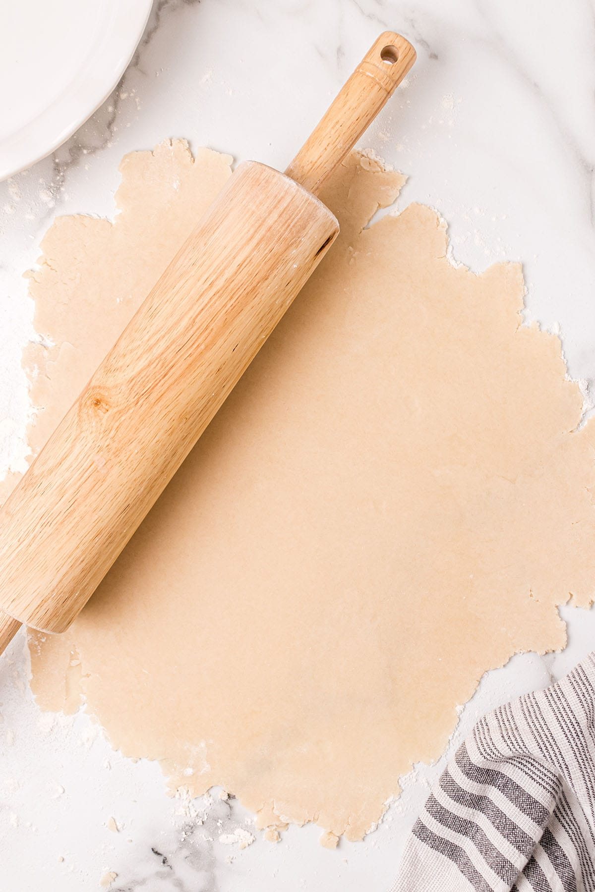 rolled out pie dough with a wooden rolling pin