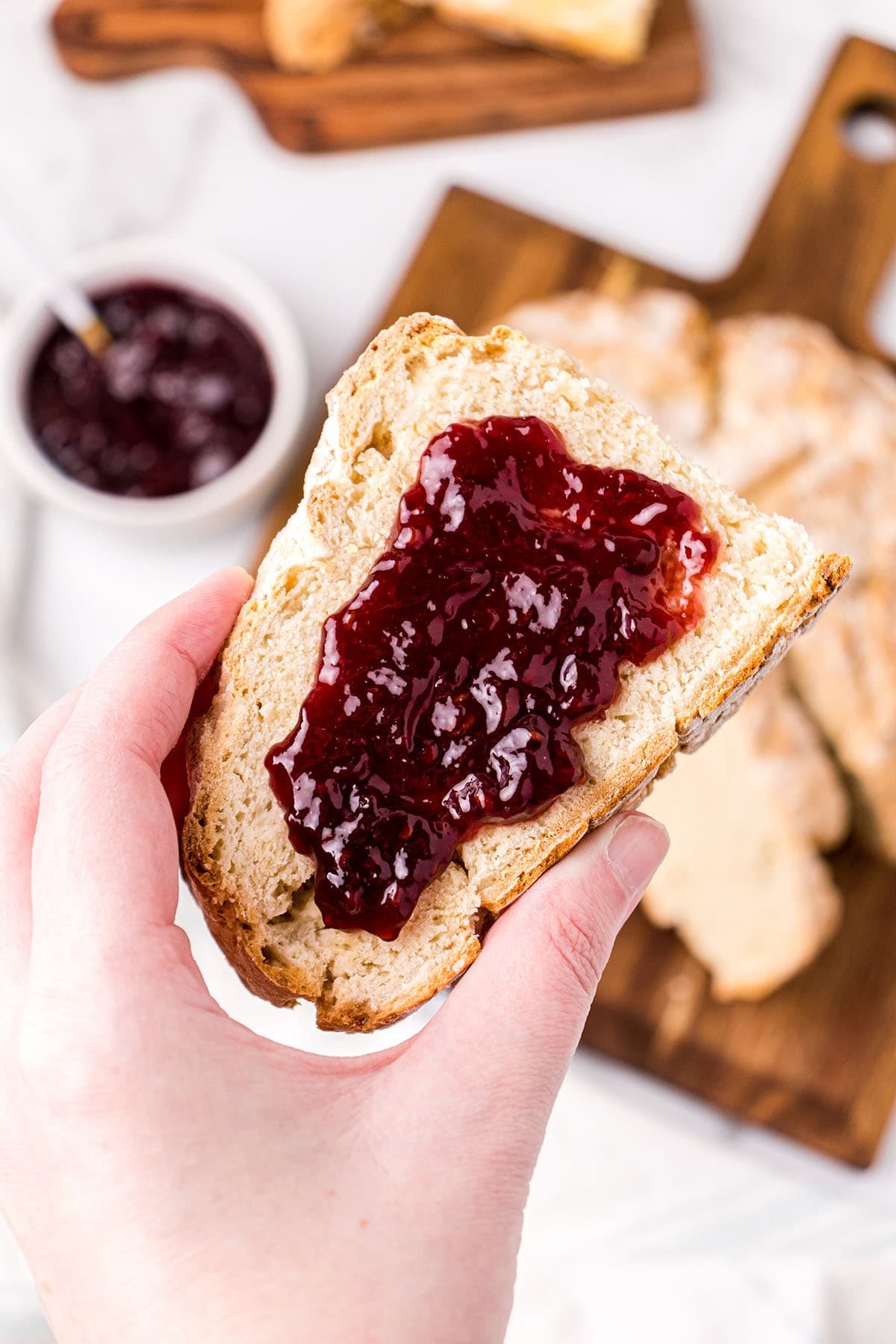 Irish soda bread with jam in woman's hand