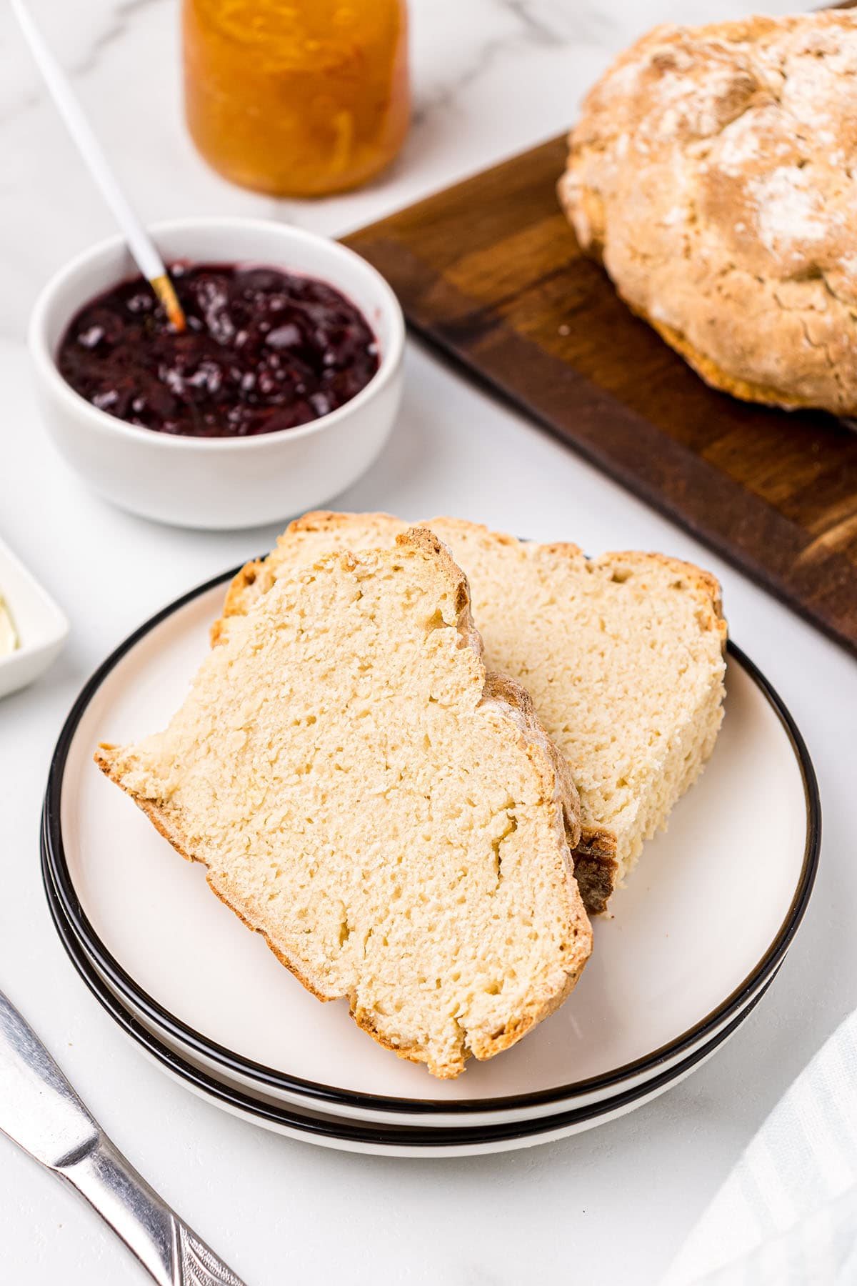 2 slices of fresh baked Irish soda bread with a bow of jam
