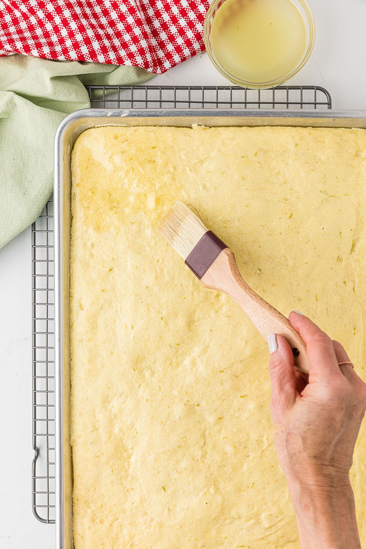 brushing lime syrup on baked cake