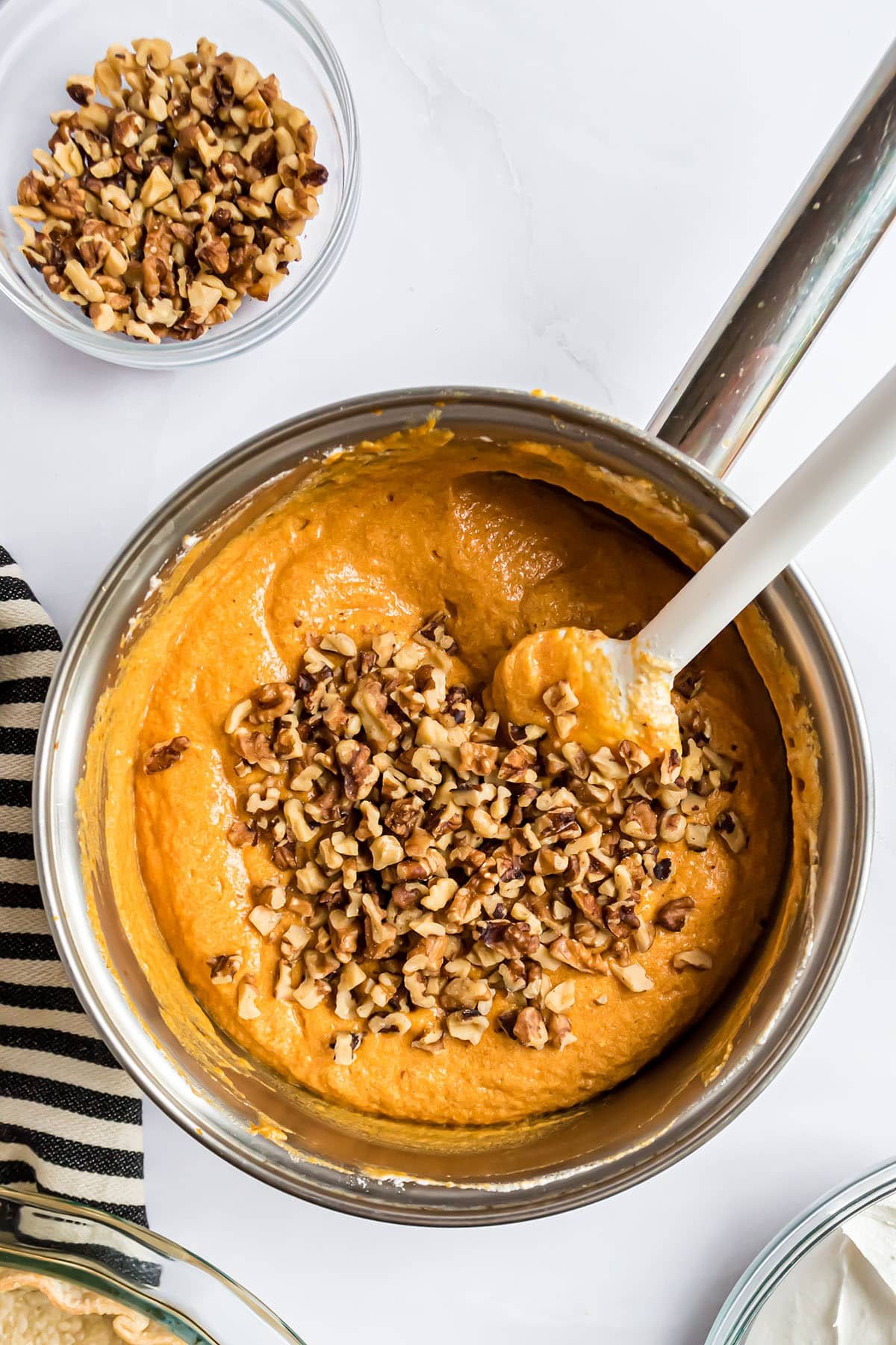 folding chopped walnuts into pumpkin pie filling with a rubber spatula