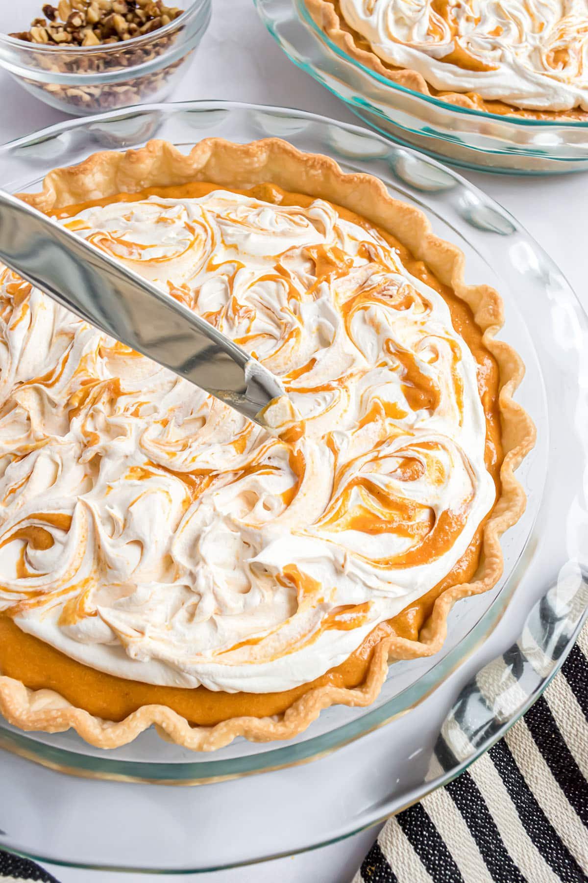 swirling CoolWhip and pumpkin pie filling with a knife for a decorative presentation.