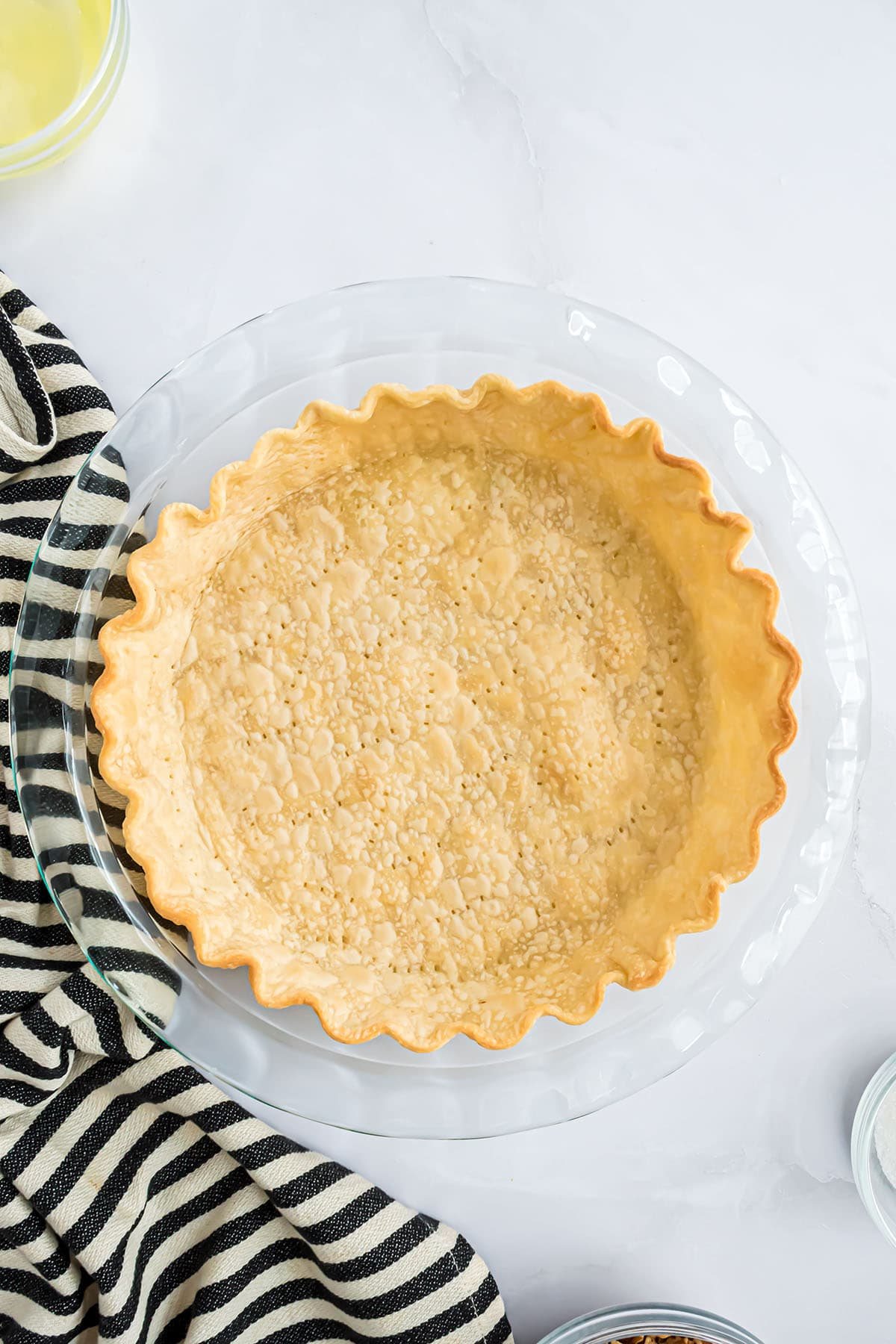 baked pie shell next to a black and white striped towel