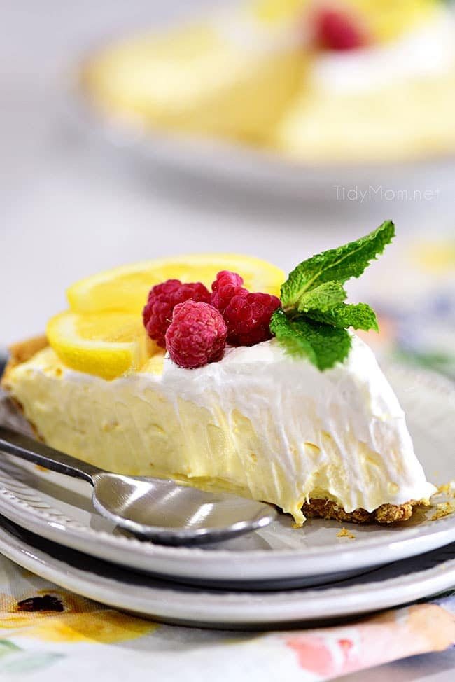 A slice of lemonade pie on a plate with a spoon