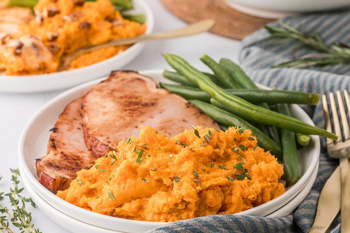 plated mashed sweet potatoes with green beans and ham