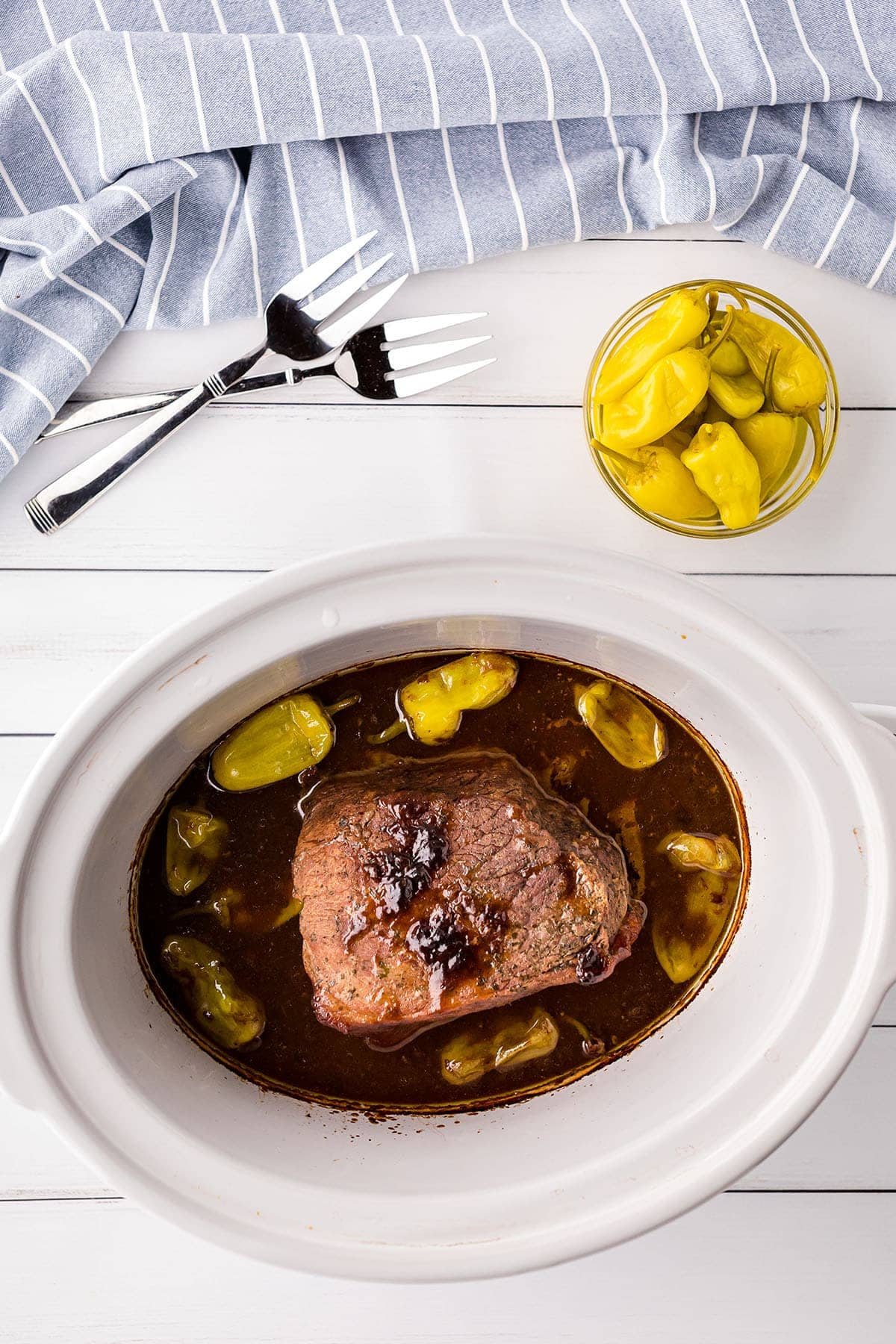 pot roast and gravy in a white crockpot