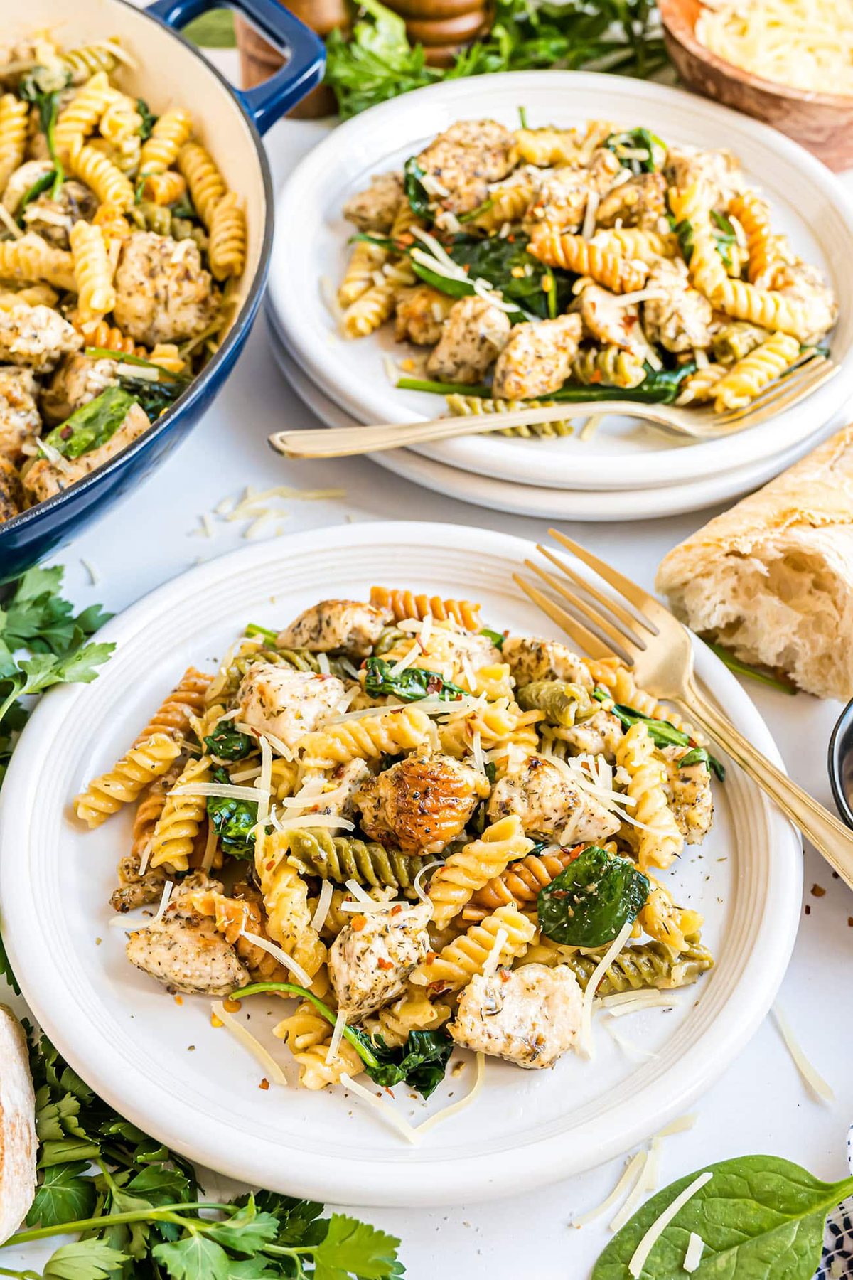 one-pan creamy garlic chicken pasta plated on white plates