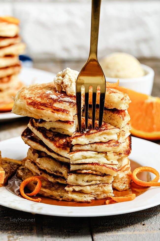 a fork digging into a stack of pancakes