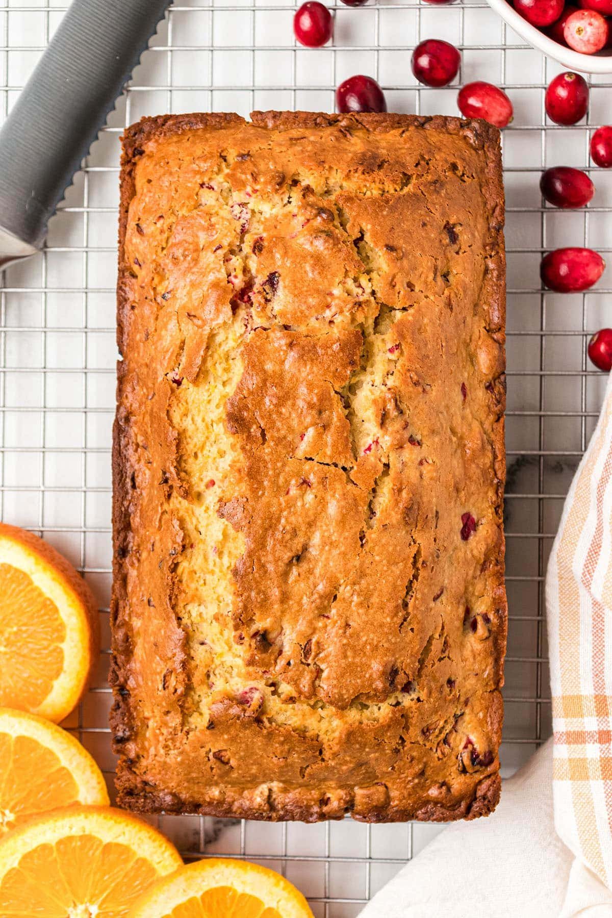 Fresh baked loaf of Orange Cranberry Bread on a wire cooling rack