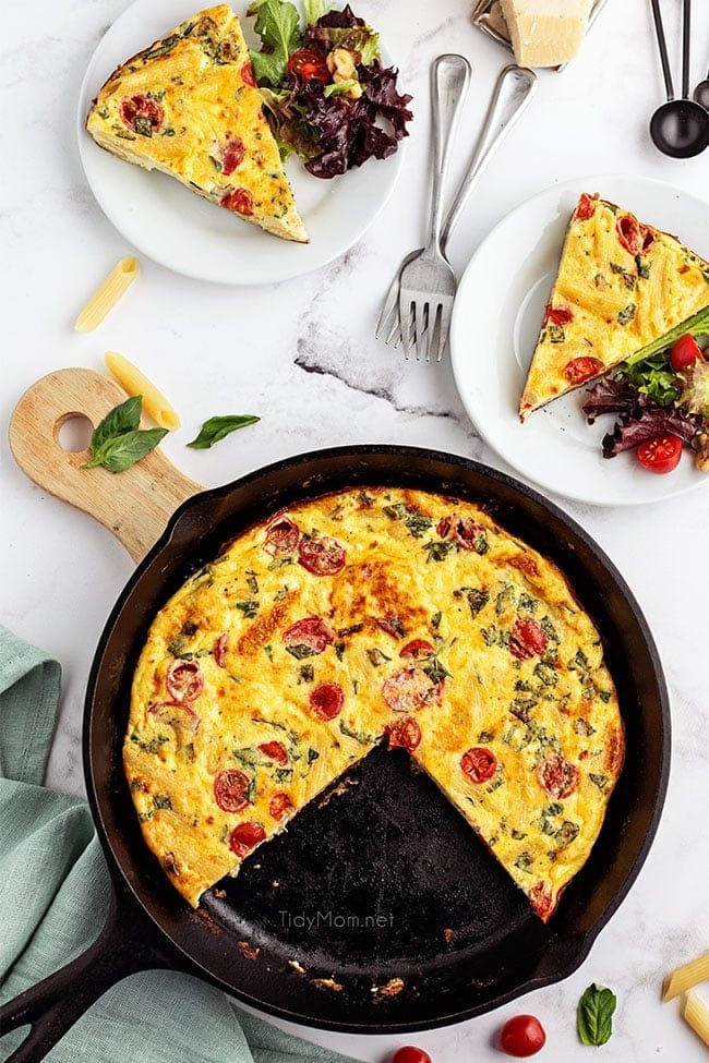 frittata in cast iron skillet with 2 servings on plates