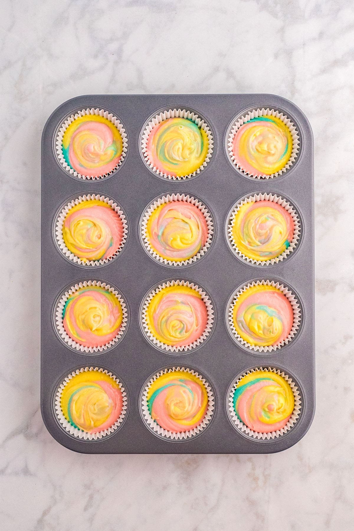 swirling 3 colors of cake batter for marble Spring cupcakes