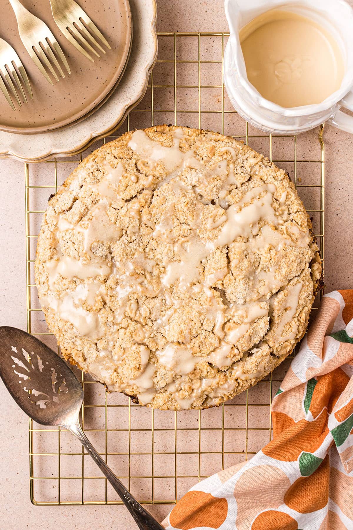 baked peach coffee cake on a cooling rack with a pie server