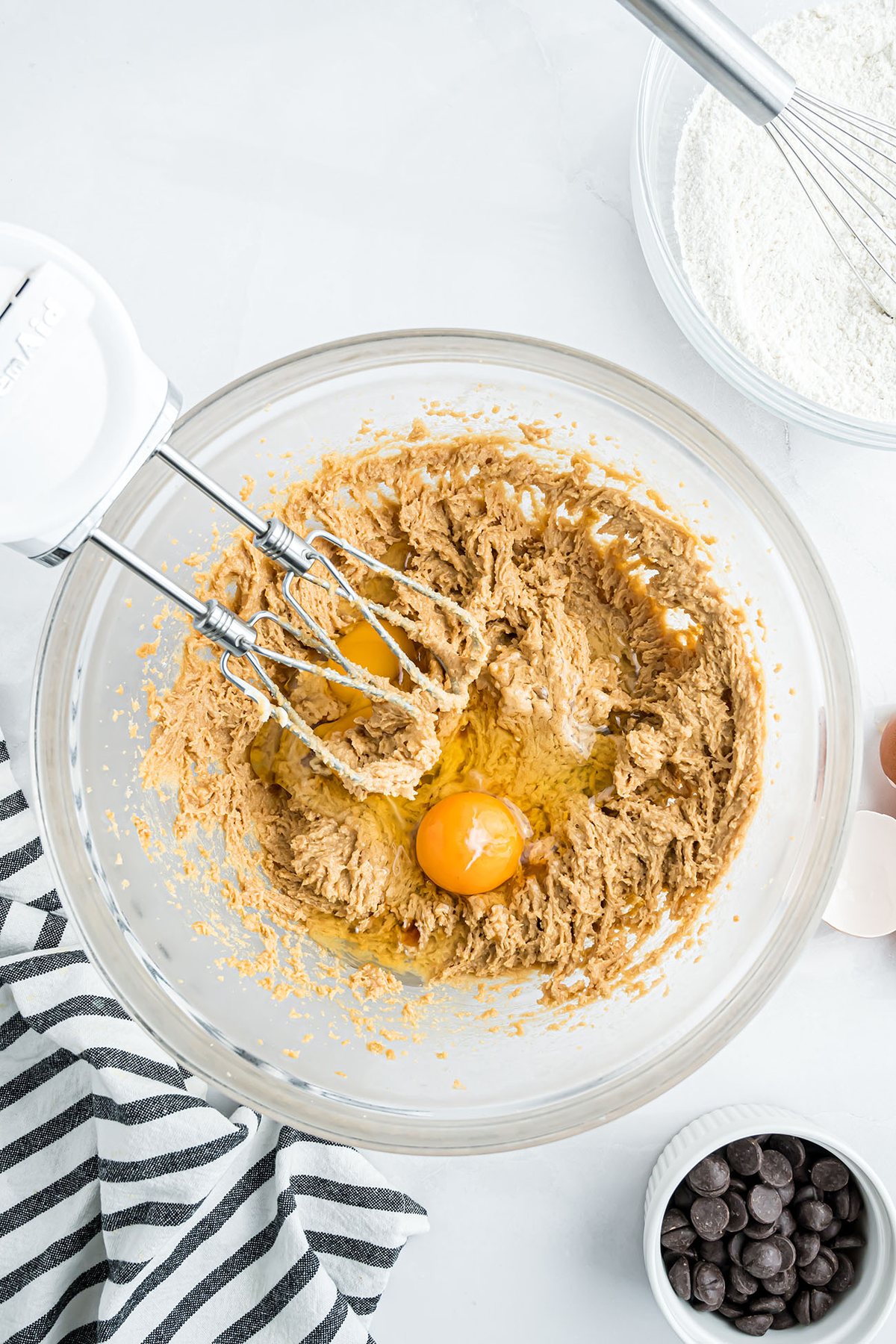 Creaming peanut butter, butter, and sugars with an electric mixer to make peanut butter blondie batter.