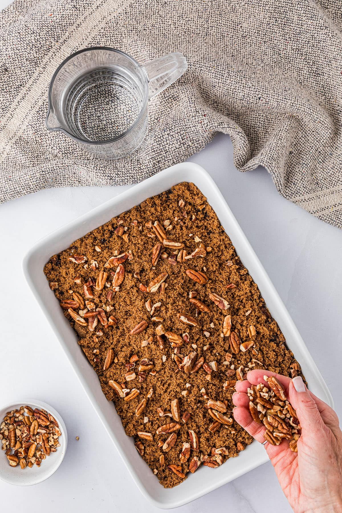 pecan cobbler step 5 adding another layer of pecans to the dessert