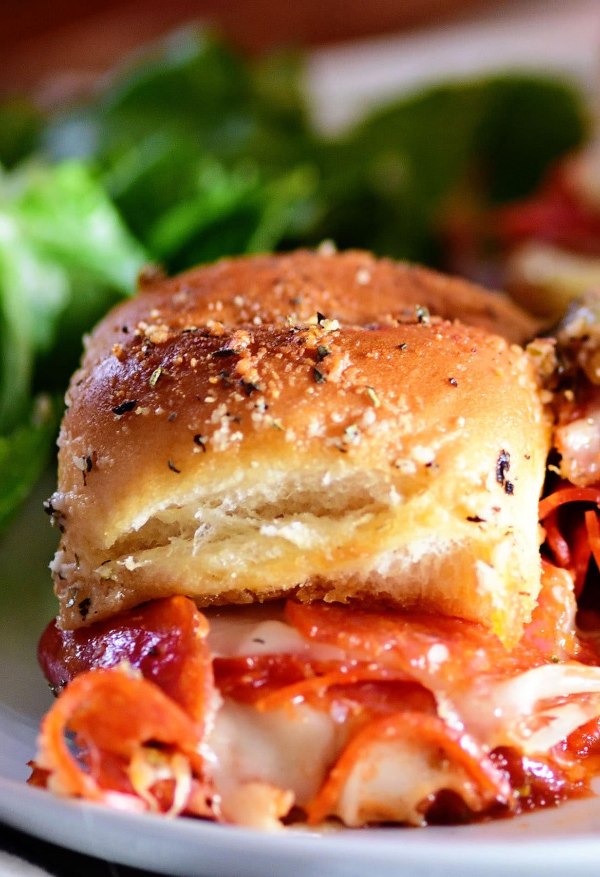 close up of a pepperoni pizza slider on a plate