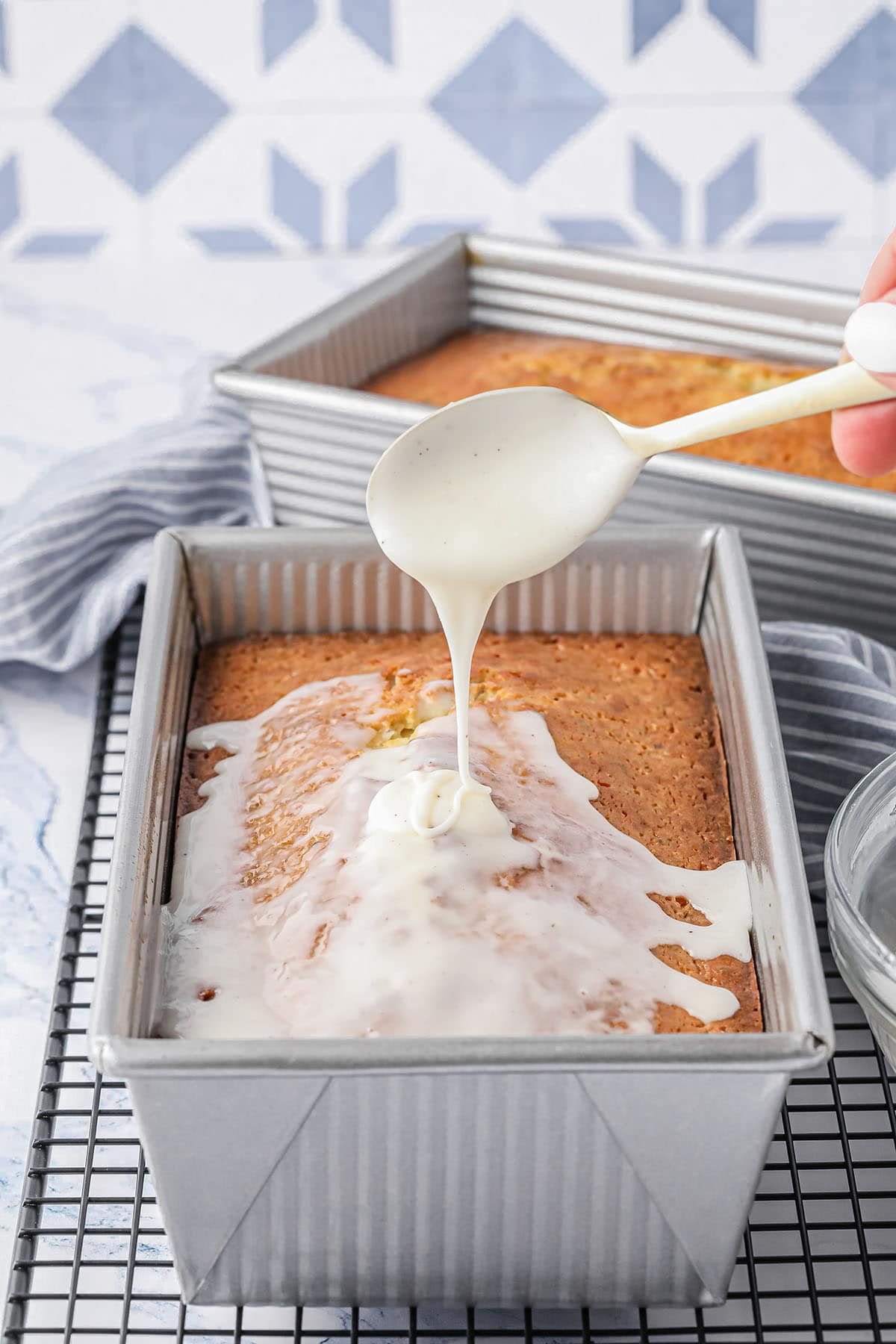 drizzling glaze on a loaf of quick bread