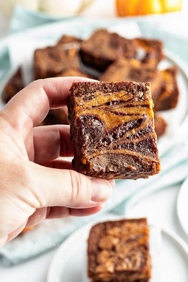 hand holding a pumpkin brownie